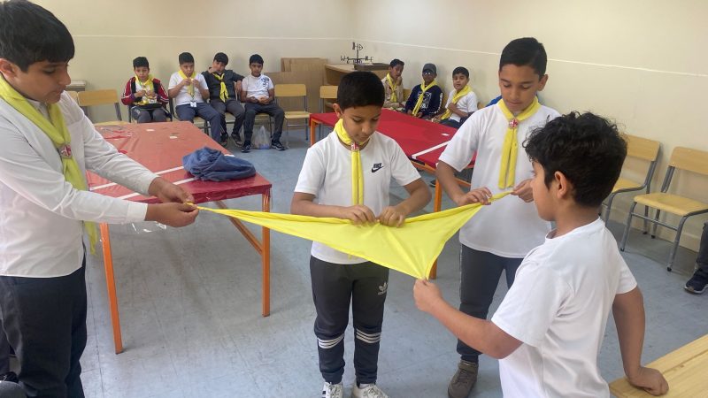 تدريب أعضاء الفرقة الكشفية على طريقة لف الوشاح الكشفي